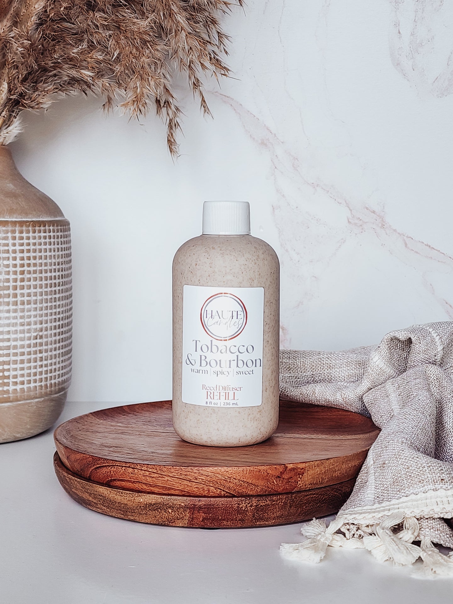 Bottle of 'Tobacco & Bourbon' on a wooden tray with decorative elements